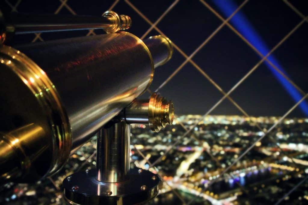 telescope with city lights at night in the background