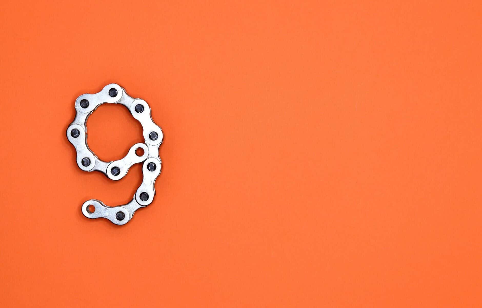 gray bicycle chain on orange surface